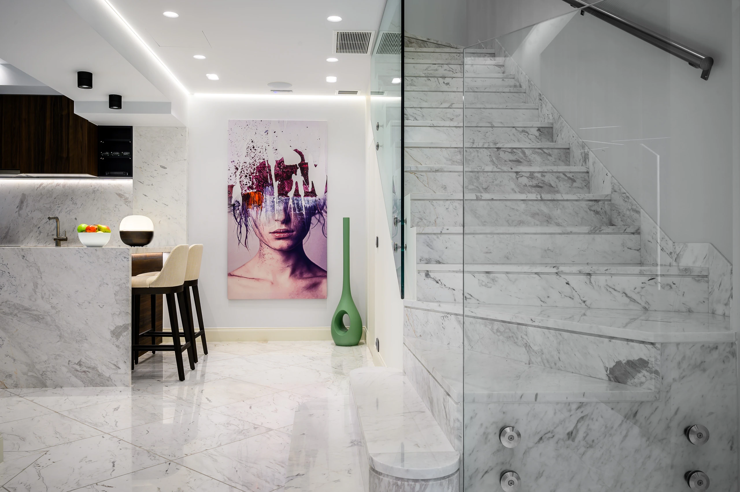 Μαρμάρινος εσωτερικός χώρος στα Mirum Villas στην Κρήτη με κουζίνα, γυάλινη σκάλα και έργο τέχνης