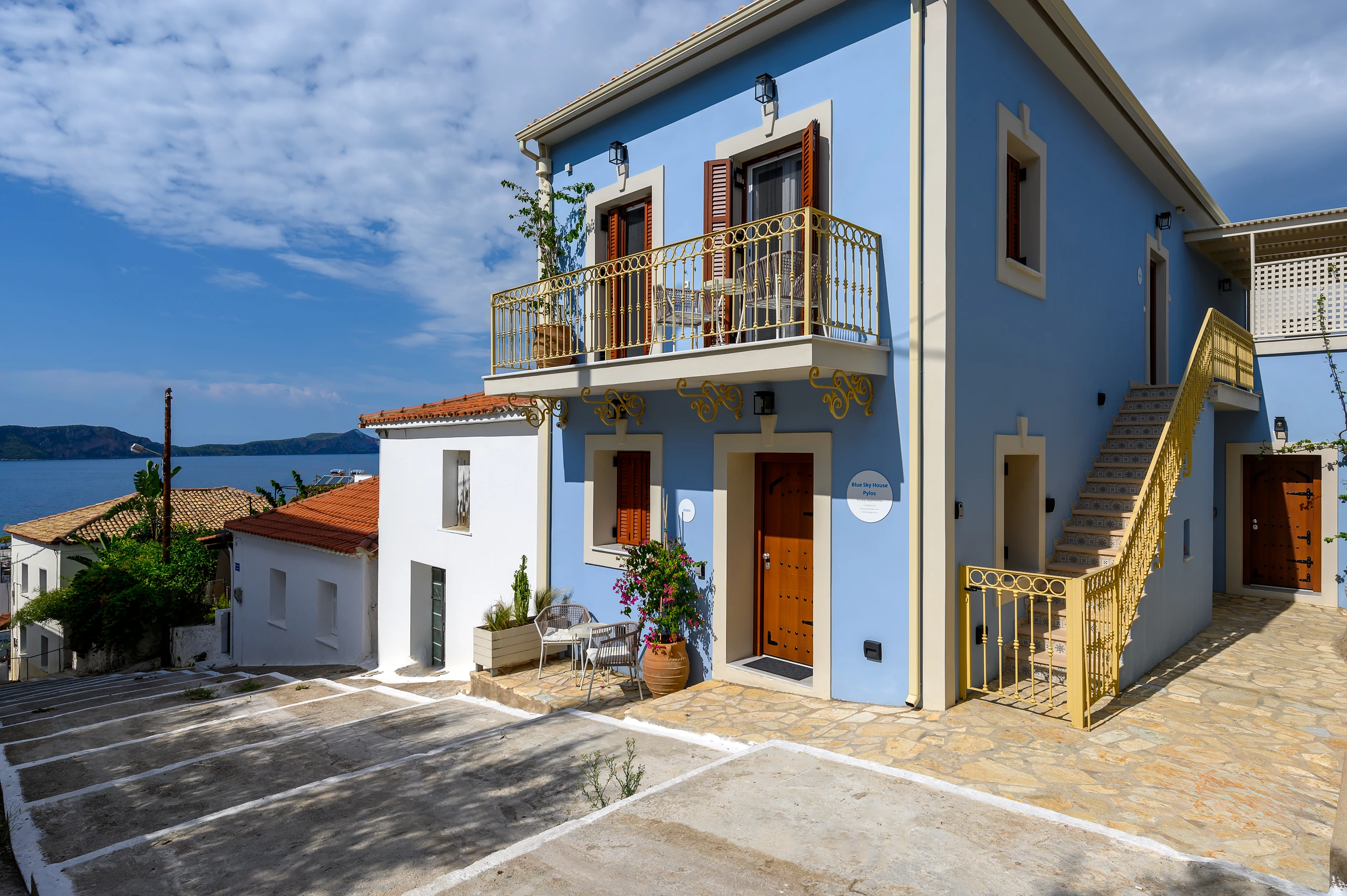 Γαλάζια κατοικία με μπαλκόνι και εξωτερική σκάλα στο Blue Sky House στην Πύλο της Πελοποννήσου.