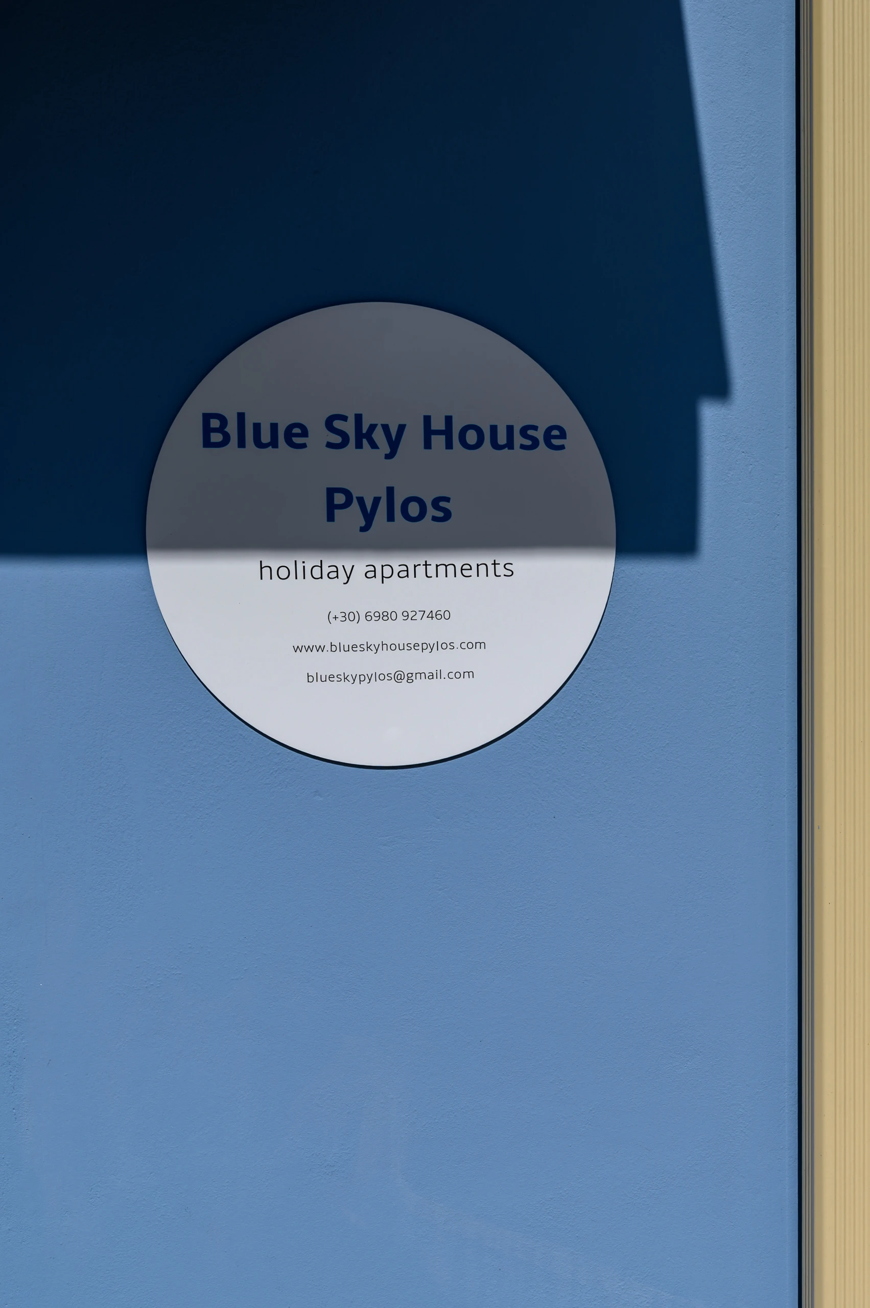 Πινακίδα του Blue Sky House σε γαλάζιο εξωτερικό τοίχο στο Blue Sky House στην Πύλο της Πελοποννήσου.