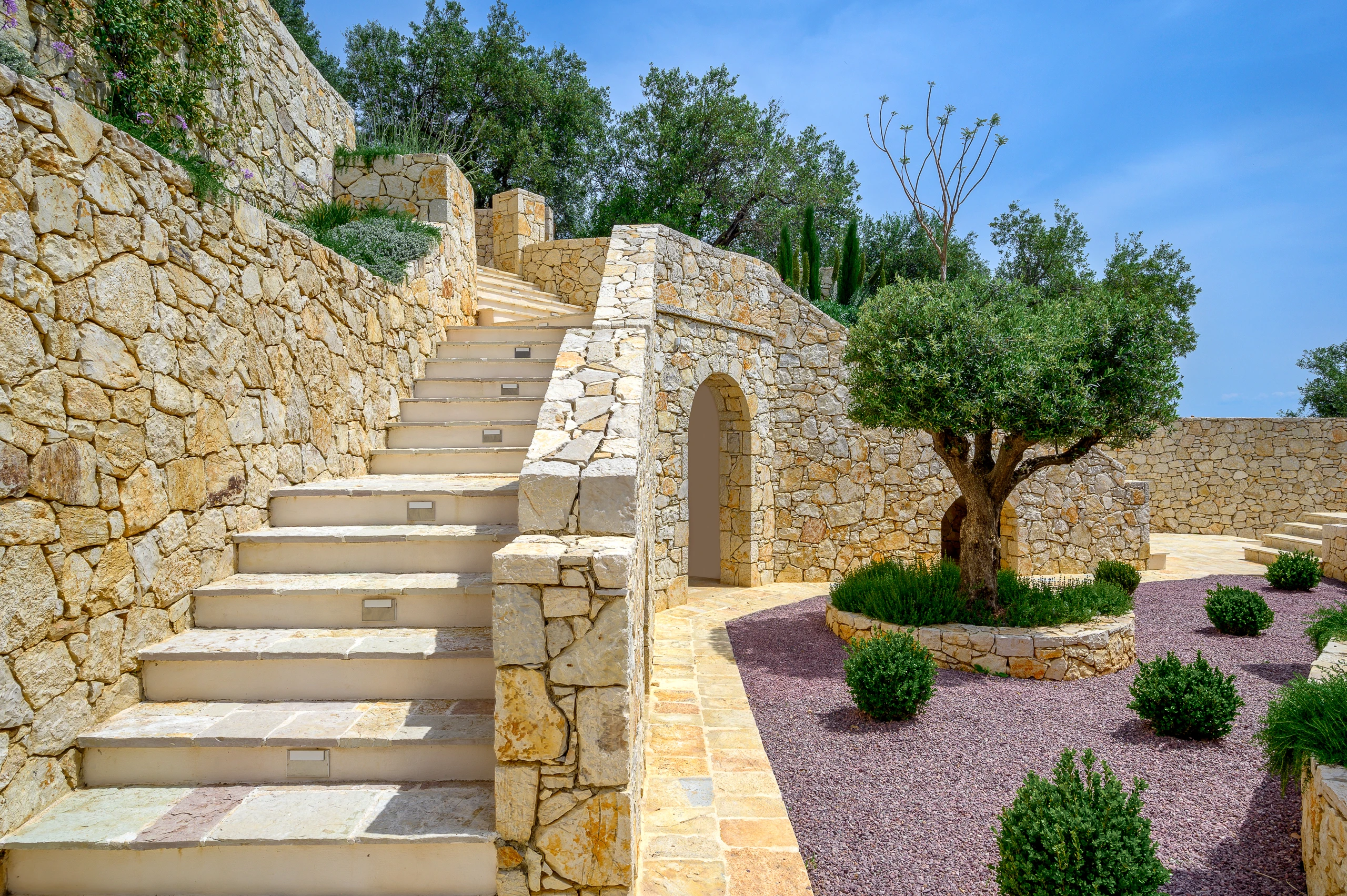 Πέτρινη εξωτερική σκάλα και κήπος της Villa Artemis