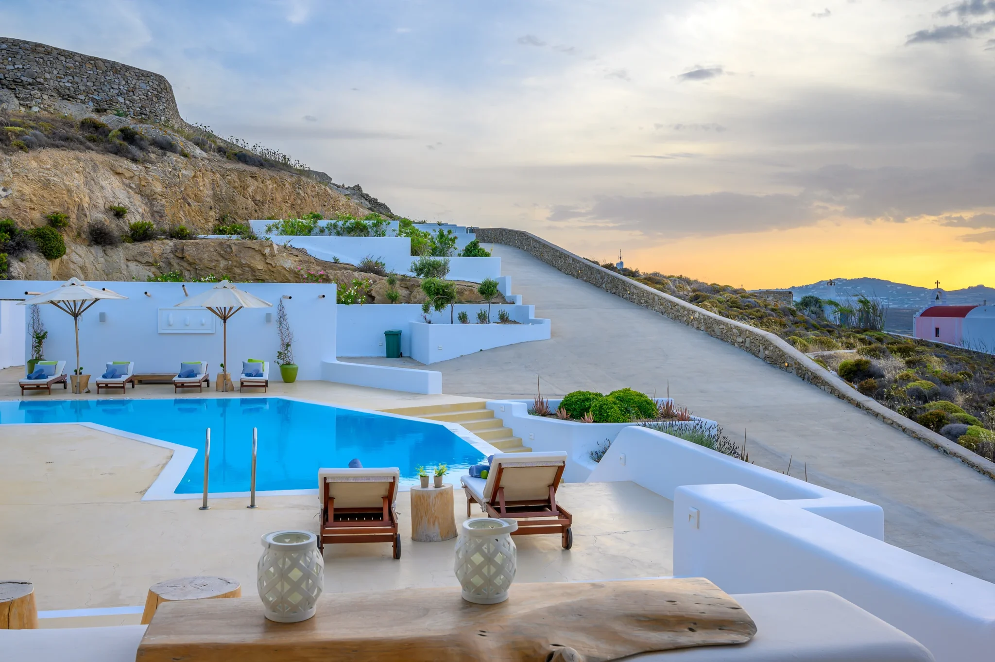 Πισινα και βεραντες της Mariposa στο φως του ηλιοβασιλεματος