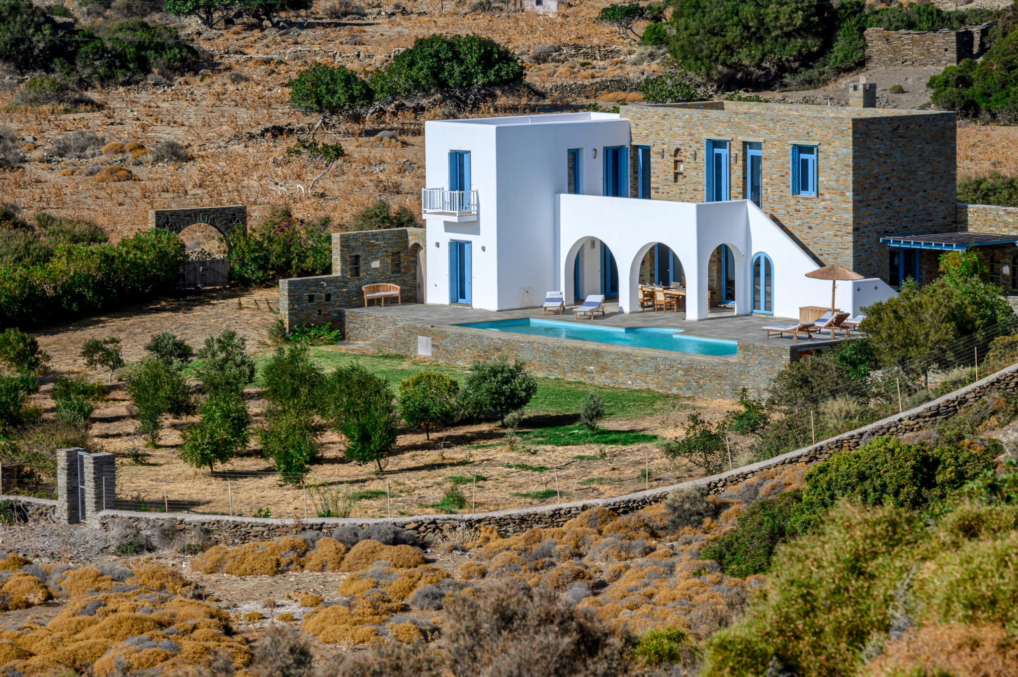 Βιλα Thalassa με λευκες καμαρες, πετρινους τοιχους και πισινα πανω απο ελαιωνα στην Ανδρο