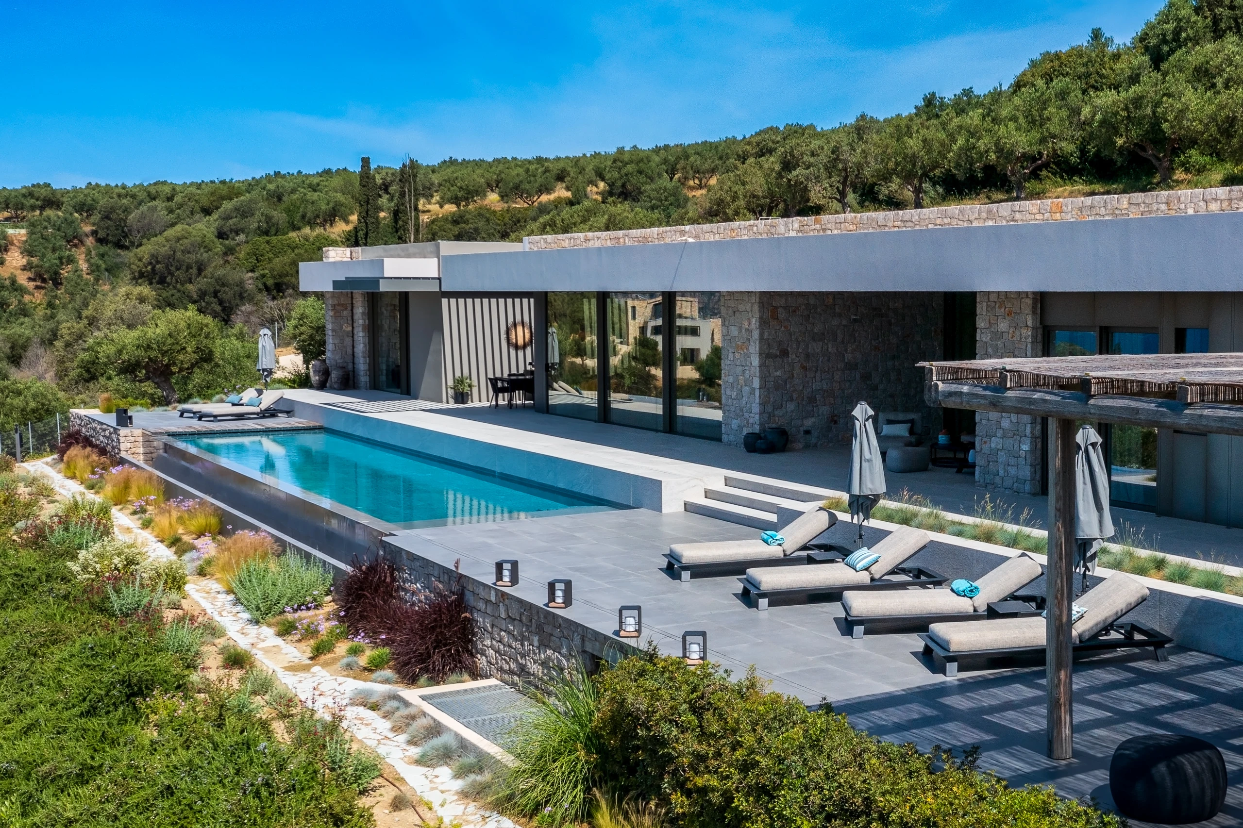 Εναέρια άποψη της Βίλας Β, της πισίνας και του φυσικού τοπίου της Πελοποννήσου.