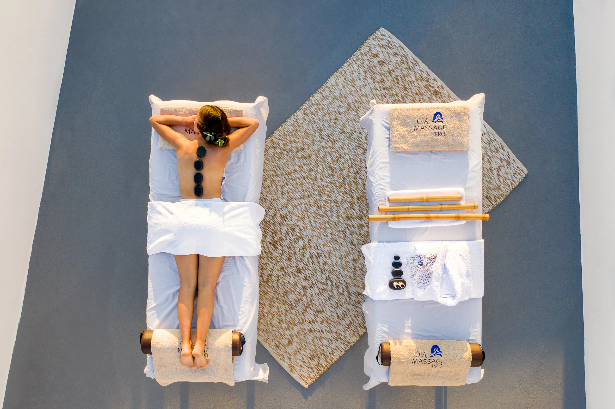 Santolia Art Boutique Suites — Υπαίθρια εμπειρία ευεξίας Κατακόρυφη εναέρια άποψη υπαίθριου χώρου ευεξίας με επισκέπτρια και ιδιωτική πισίνα στο Santolia Art Boutique Suites.